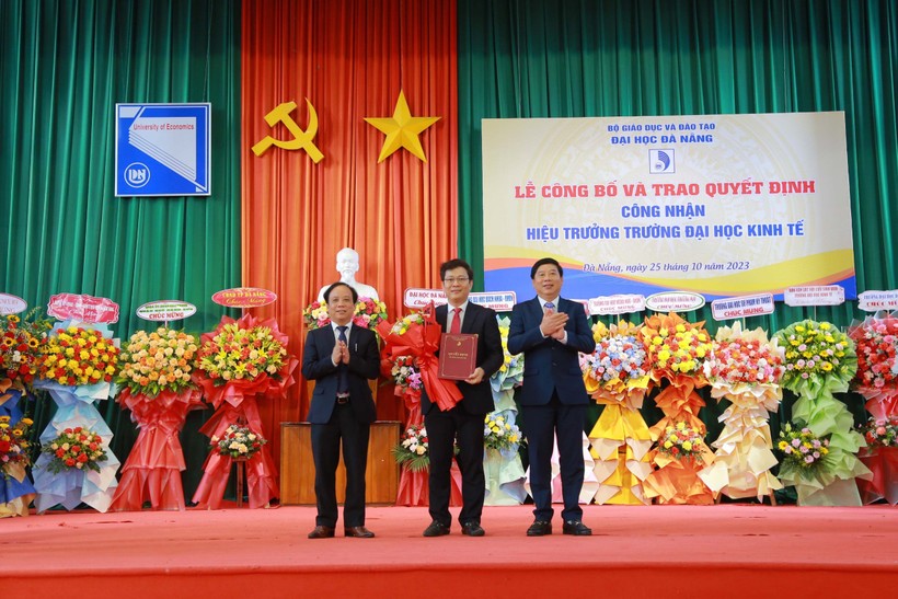 Giám đốc ĐH Đà Nẵng (trái) và Chủ tịch Hội đồng trường Trường ĐH Kinh tế (phải) trao quyết định công nhận Hiệu trưởng cho PGS.TS Lê Văn Huy. 