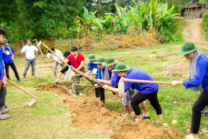 Sinh viên tình nguyện san đất làm sân bóng cho trẻ em thôn Chi Nêết.