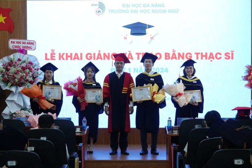 Đại diện BGH Trường ĐH Ngoại ngữ, ĐH Đà Nẵng khen thưởng 4 tân thạc sĩ tốt nghiệp thủ khoa. 