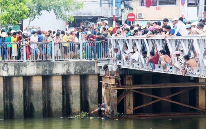 Hàng trăm người dân tập trung theo dõi việc vớt xác nam sinh dưới chân cầu tạm.