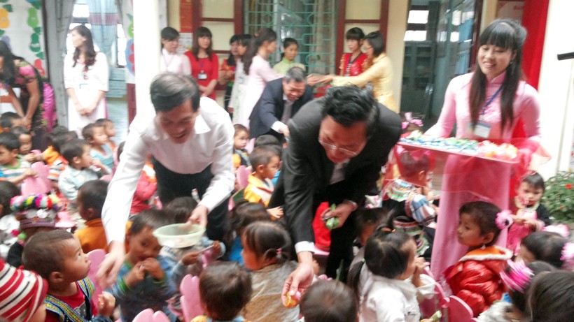 Bộ trưởng Phạm Vũ Luận cùng Phó Bí thư Thường trực Tỉnh ủy Lai Châu Đỗ Ngọc An chia kẹo cho các cháu học sinh