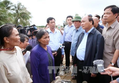Thủ tướng Nguyễn Xuân Phúc thăm hỏi nhân dân vùng bị lũ lụt tại xã Mỹ Chánh, huyện Phù Mỹ, tỉnh Bình Định. Ảnh: Thống Nhất/TTXVN.