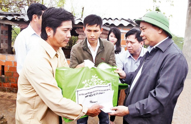 Thủ tướng Nguyễn Xuân Phúc thăm hỏi, tặng quà các hộ gia đình bị thiệt hại tại thị trấn Diêu Trì, huyện Tuy Phước. Ảnh: TTXVN