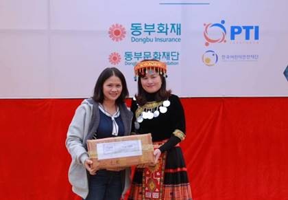 Bà Trần Bích Hợp -  đại diện Tổng Công ty Bảo hiểm Bưu điện (PTI) trao quà tại trường THCS Nùng Nàng
