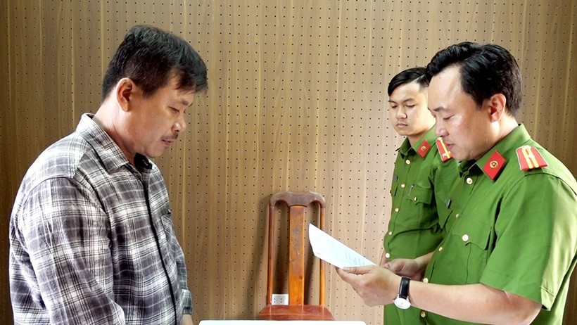 Lực lượng chức năng tống đạt các quyết định và lệnh tạm giam bị can Nguyễn Văn Nam. (Ảnh: Tiến Tầm) 