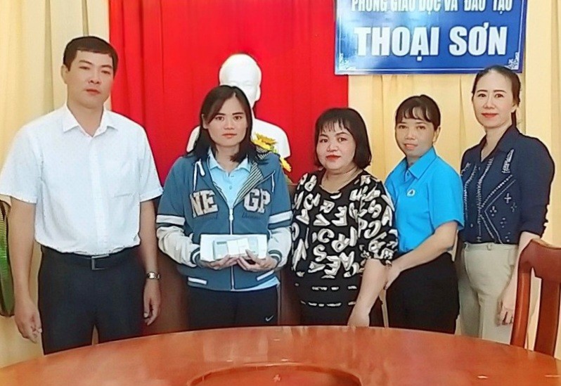 Thầy Nguyễn Anh Tuấn - Phó trưởng Phòng GD&ĐT Thoại Sơn chuyển trao tiền của đồng nghiệp cùng các nhà hảo tâm và bạn đọc Báo GD&TĐ cho cô Đỗ Thị Thanh Thẩm. 
