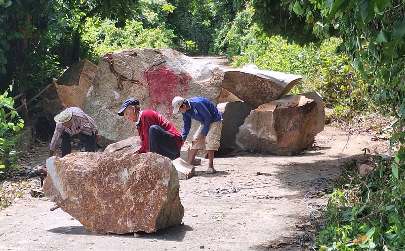 Công nhân xử lý những tảng đá rơi trên núi xuống. (Ảnh: Trọng Nhân)