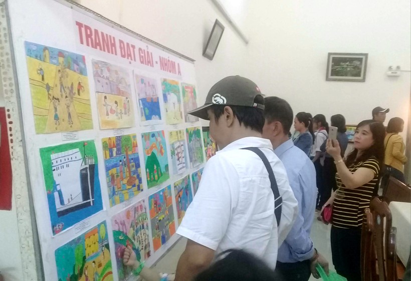 Giáo viên và phụ huynh tham quan triển lãm tranh của thiếu nhi An Giang trong một hội thi.