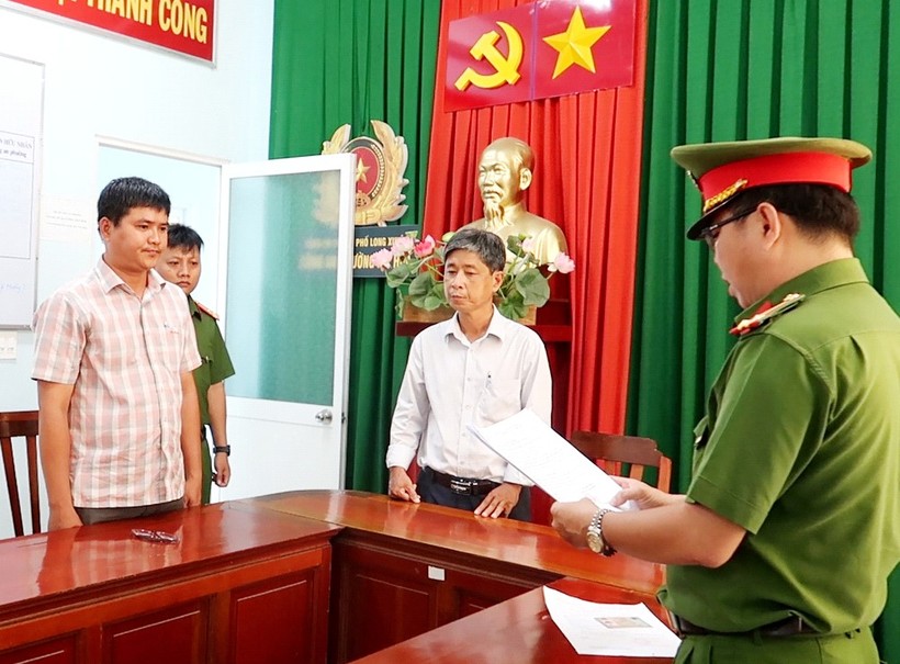 Cơ quan Công an tống đạt các Quyết định và Lệnh bắt tạm giam đối với bị can Nguyễn Thanh Phong (áo sọc). (Ảnh: Tiến Tầm)