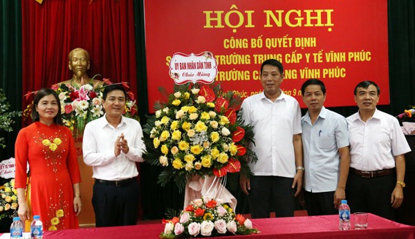 Ông Vũ Việt Văn, Phó Chủ tịch UBND tỉnh Vĩnh Phúc (thứ 2 từ trái qua) tặng hoa chúc mừng BGH Trường Cao đẳng Vĩnh Phúc