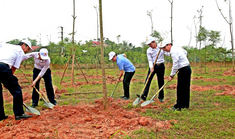 Ông Lê Duy Thành (áo xanh) cùng các đại biểu trồng cây tại trường THPT Ngô Gia Tự