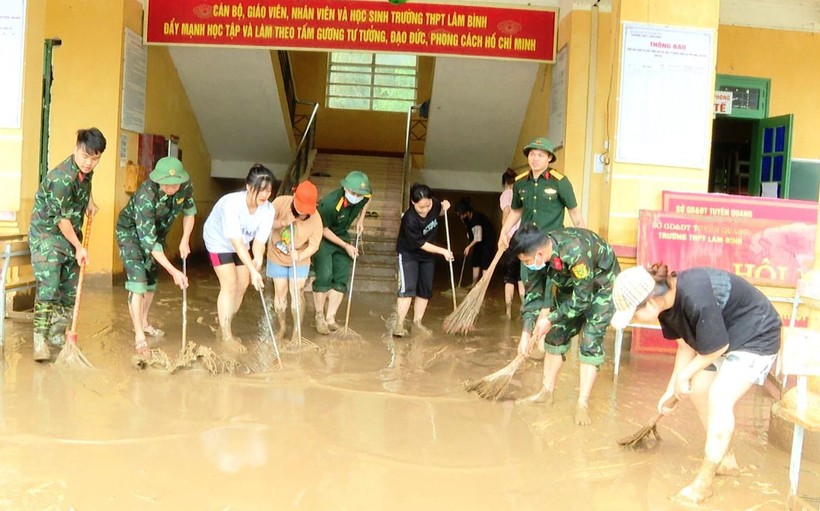 Dọn dẹp bùn đất sau khi nước rút tại trường THPT Lâm Bình. Ảnh: Hà Khánh