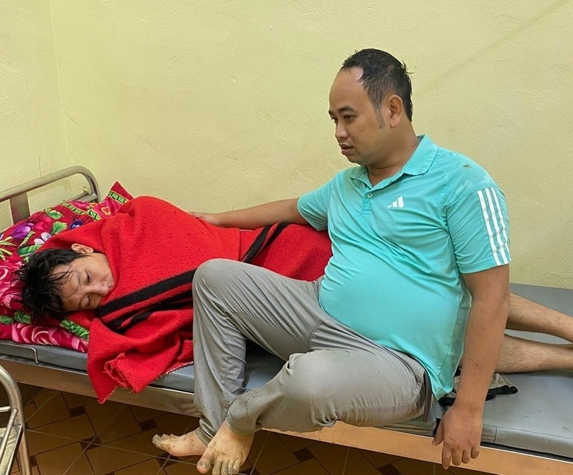 Thiếu tá Đỗ Quang Tân (người ngồi) chăm sóc nạn nhân bị đuối nước tại Trạm y tế xã. Ảnh: Công an huyện Hoàng Su Phì
