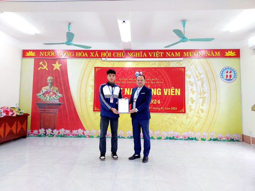 Thầy giáo Nguyễn Anh Tuân – Bí thư chi bộ, Hiệu trưởng nhà trường trao quyết định kết nạp Đảng cho học sinh Quàng Tiến Đạt.