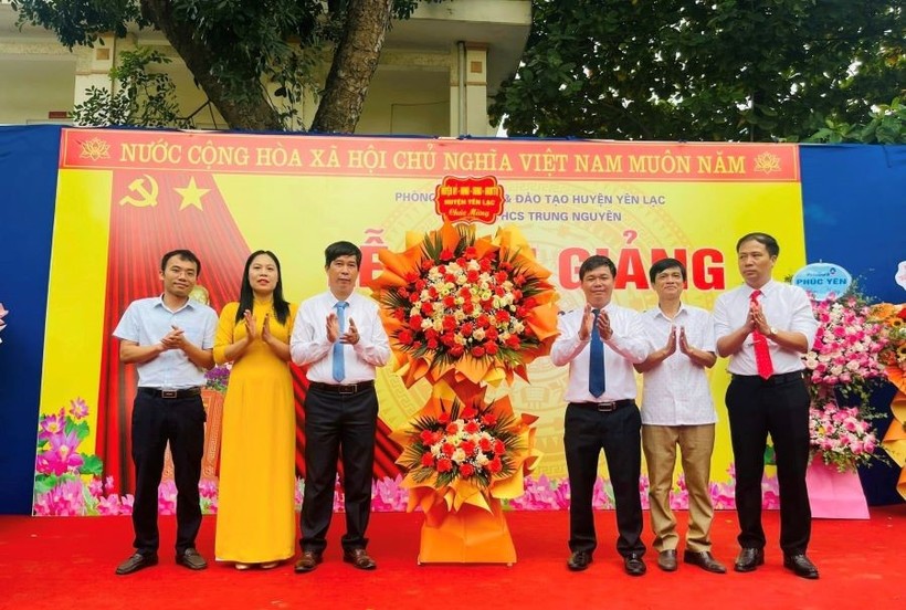 Đại diện Huyện ủy, HĐND, UBND huyện Yên Lạc (bên phải) tặng hoa chúc mừng thầy và trò trường THCS Trung Nguyên nhân dịp khai giảng năm học mới.