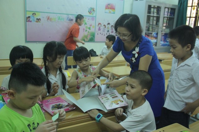 Cô Nguyễn Thị Kim Dung và học trò chuẩn bị sách vở, đồ dùng dạy học. Những tấm kê tay cô giáo mua tặng khiến các học trò rất thích thú.