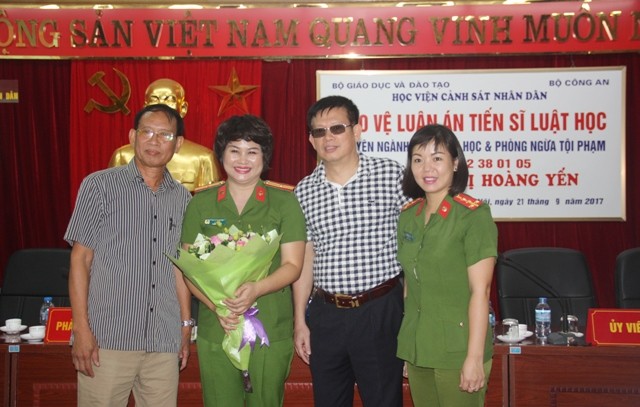 Thiếu tá Vũ Thị Hoàng Yến (cầm hoa) trong buổi bảo vệ luận án tiến sĩ chiều 21/9
