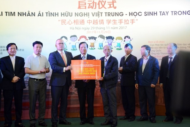 Đại diện Tổng hội Từ thiện Trung Quốc trao tượng trưng  món quà là 1.000 chiếc cặp cho học sinh  Việt Nam