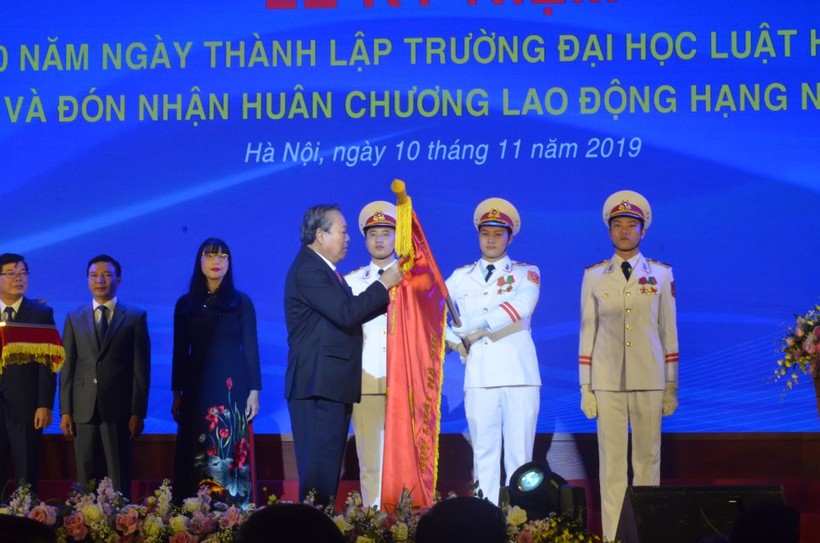 Phó Thủ tướng Chính phủ Trương Hòa Bình gắn Huân chương trong nghi lễ đón nhận Huân chương Lao động hạng nhất của Trường ĐH Luật Hà Nội.