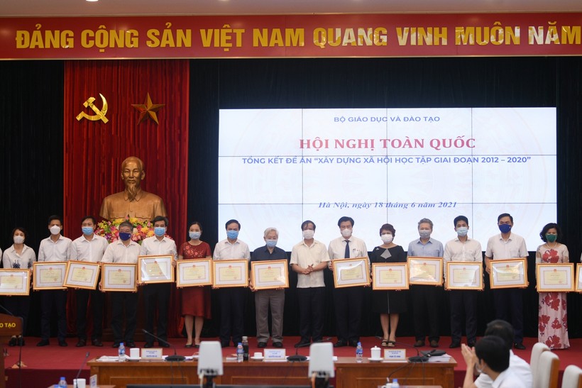 Bộ trưởng Bộ GD&ĐT Nguyễn Kim Sơn trao bằng khen của Bộ trưởng Bộ GD&ĐT cho các tập thể, cá nhân có thành tích xuất sắc trong công tác triển khai thực hiện Đề án “Xây dựng xã hội học tập” giai đoạn 2012 - 2020.