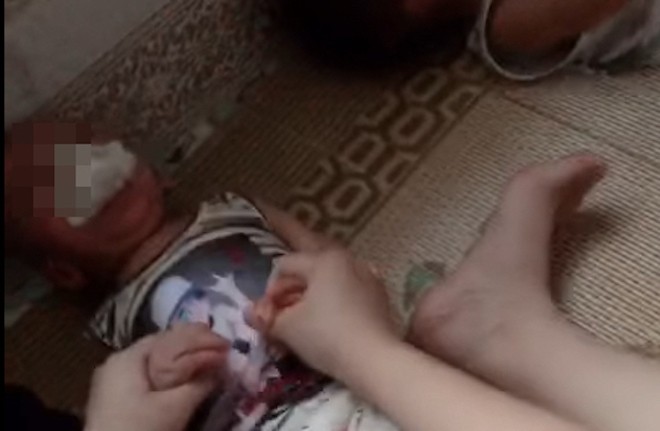 Hình ảnh cắt từ clip cháu bé khoảng 1 tuổi bị nhét giẻ vào miệng.