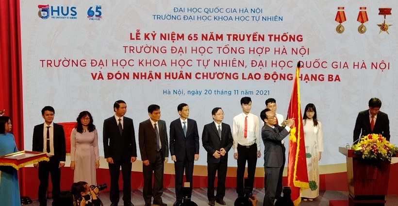 Thứ trưởng Hoàng Minh Sơn thừa ủy quyền của Chủ tịch nước gắn Huân chương Lao động hạng Ba lên lá cờ truyền thống của Trường ĐH Khoa học Tự nhiên, ĐHQG Hà Nội.