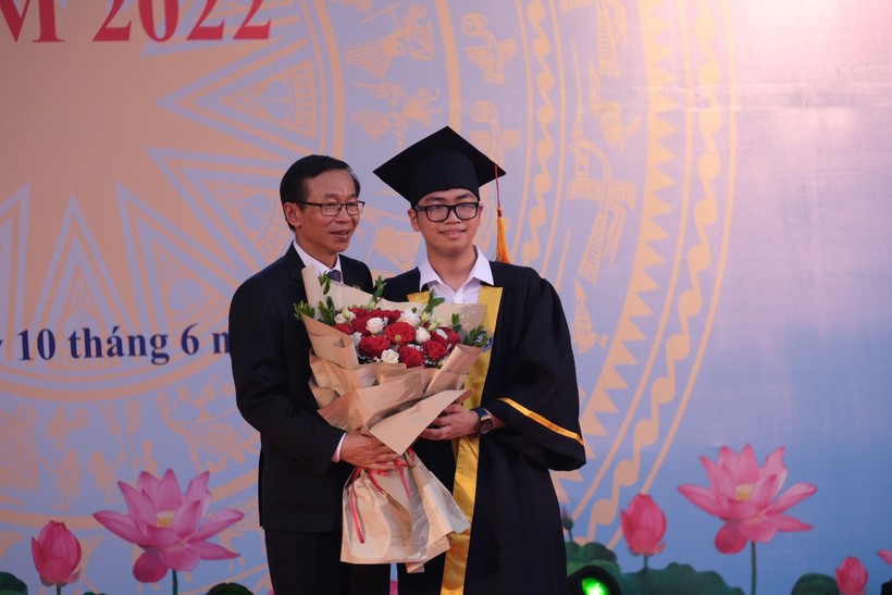 GS.TS Nguyễn Văn Minh trao cuốn thư và hoa chúc mừng cho tân cử nhân tốt nghiệp xuất sắc.
