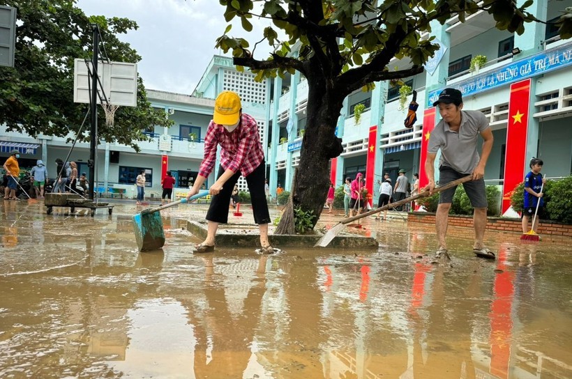 Giáo viên và phụ huynh Trường Tiểu học Hồng Quang (Đà Nẵng) dọn bùn non sau khi nước rút. Ảnh: Hoàng Hải.
