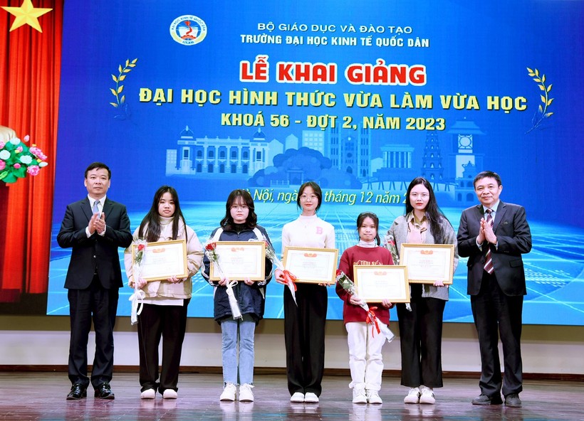 PGS.TS Bùi Huy Nhượng - Phó Hiệu trưởng và PGS.TS Phạm Quang - Trưởng khoa Đại học Tại chức trao giấy khen và tặng hoa chúc mừng cho các tân sinh viên.