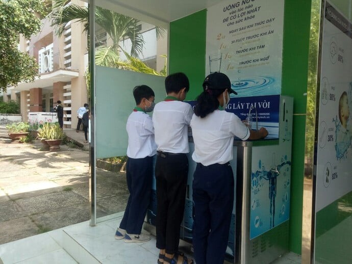 Học sinh sử dụng hệ thống nước uống sạch trong trường học. 