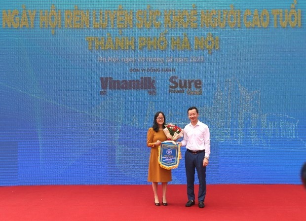 Bà Nguyễn Minh Tâm - Giám đốc Chi nhánh Vinamilk Hà Nội – đại diện Vinamillk nhận hoa và cờ từ Sở Văn hóa và Thể thao Hà Nội.