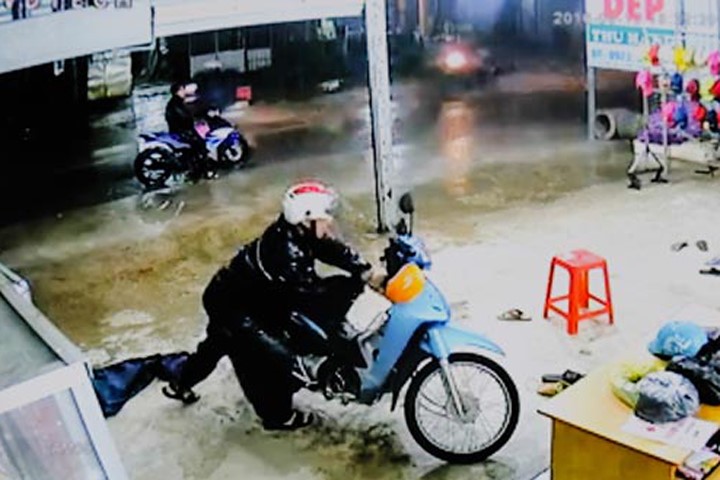 Hai đối tượng mặc áo mưa trộm xe máy của anh Hoàng Xuân Nam. Ảnh trích xuất từ camera.