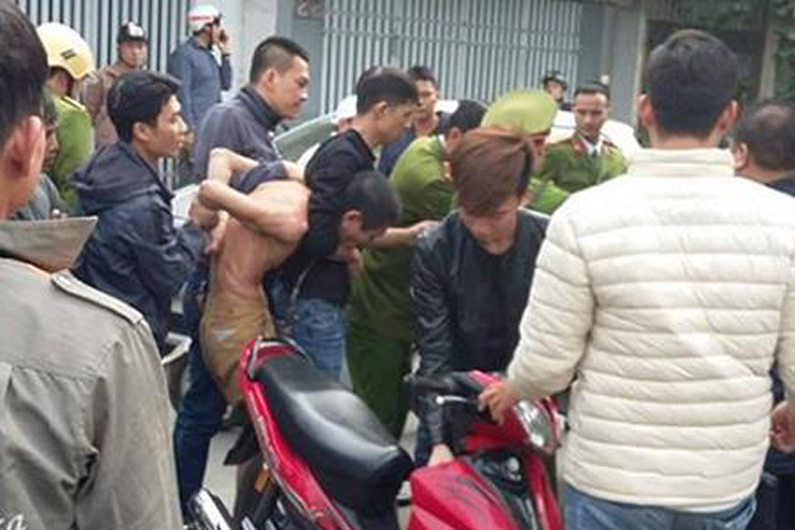 Phạm Huy Khôi (không mặc áo) bị khống chế. Ảnh: Báo Thanh niên