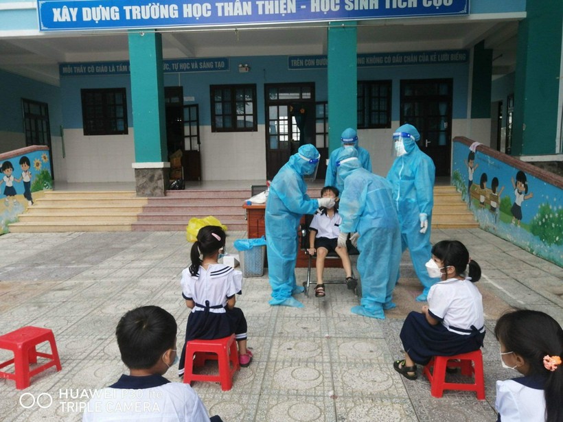Học sinh trường Tiểu học Thạnh An (huyện Cần Giờ, Thành phố Hồ Chí Minh) được các nhân viên y tế lẫy mẫu xét nghiệm Covid-19.
