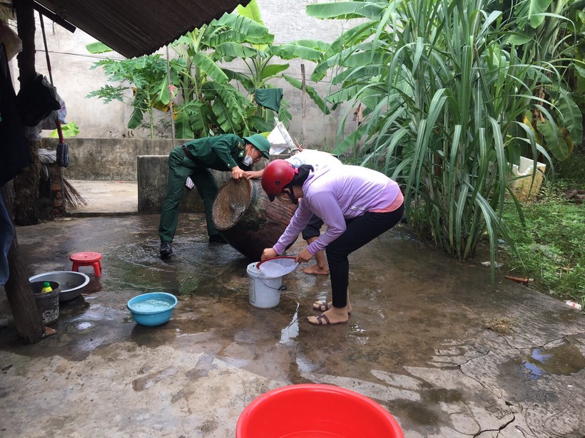 Cán bộ đồn Biên phòng Vĩnh Châu tuyên truyền và giúp người dân vệ sinh các dụng cụ chứa nước.