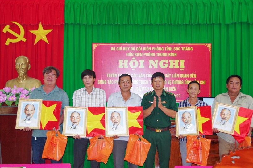 Thiếu tá Nguyễn Thanh Phong, đồn trưởng đồn Biên phòng Trung Bình tặng cờ Tổ quốc và ảnh Bác Hồ cho các chủ phương tiện.