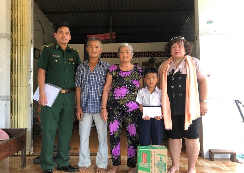 Đại diện đồn Biên phòng Côn Đảo và Công ty Bất động sản Elly Nguyễn trao quyết định nhận đỡ đầu và tặng quà cho em Nguyễn Hoàng Phi.