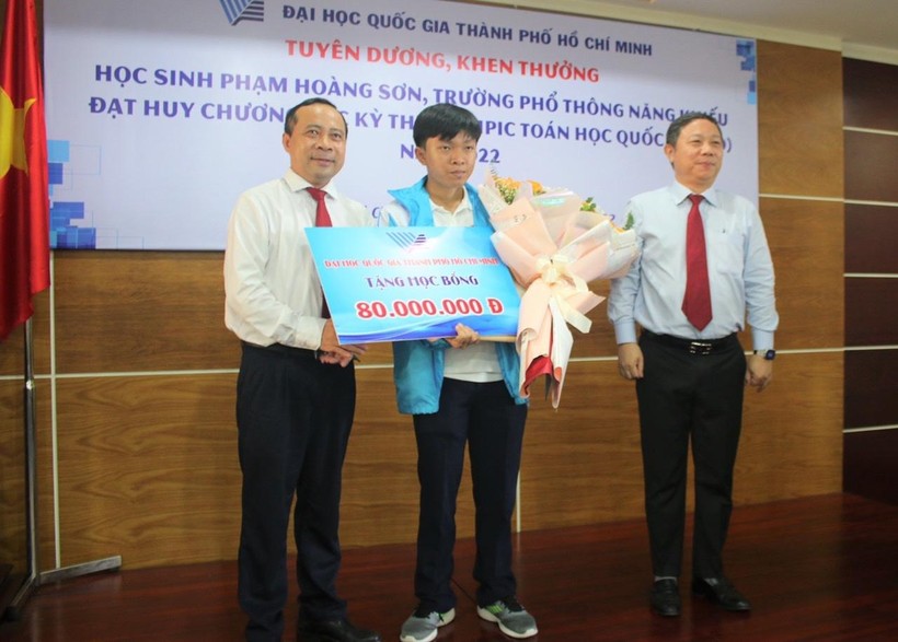 PGS.TS Vũ Hải Quân, Giám đốc Đại học quốc gia TPHCM và ông Dương Anh Đức, Phó Chủ tịch UBND TPHCM trao giấy khen và học bổng cho Phạm Hoàng Sơn.