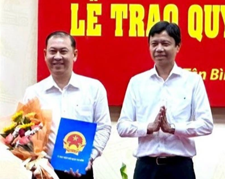 Ông Nguyễn Bá Thành, chủ tịch UBND quận Tân Bình trao quyết định bổ nhiệm Trưởng phòng GD&ĐT cho ông Phan Văn Quang (trái). Ảnh: GIA HUY.