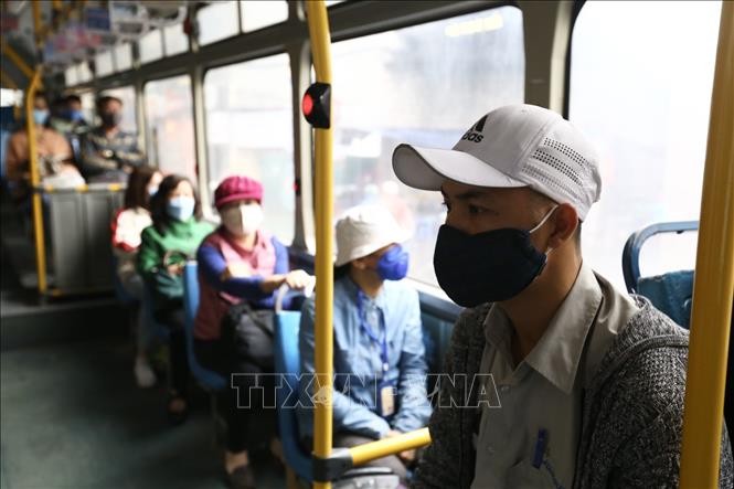 Hành khách thực hiện đeo khẩu trang khi tham gia giao thông trên xe buýt công cộng, ảnh chụp tháng 3/2020. Ảnh: Minh Quyết/TTXVN
