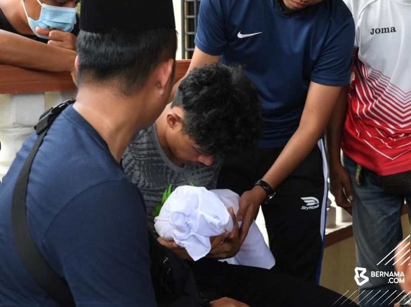 Syafiq Ahmad đau đớn bế cậu con trai 22 ngày tuổi đã qua đời. 