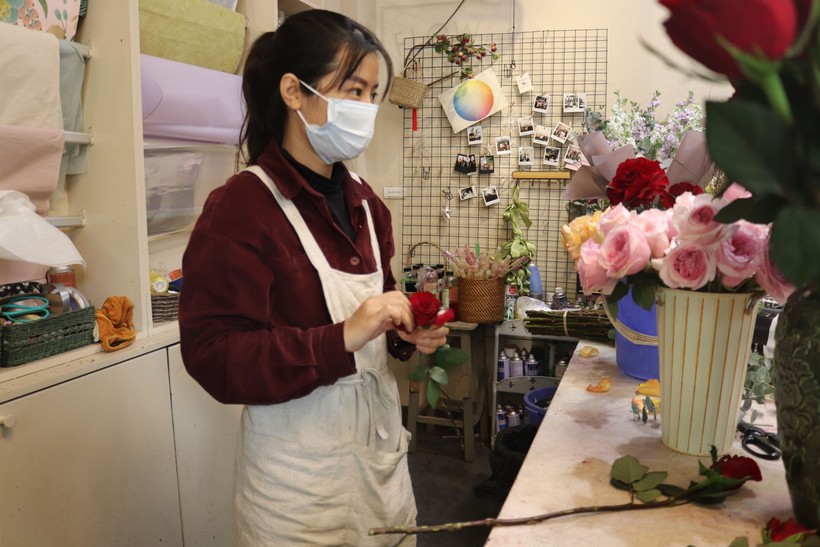 Chị Đinh Hồng Ngọc - Quản lý shop hoa trên phố Nguyễn Cao, Hà Nội giới thiệu với khách mua hoa.