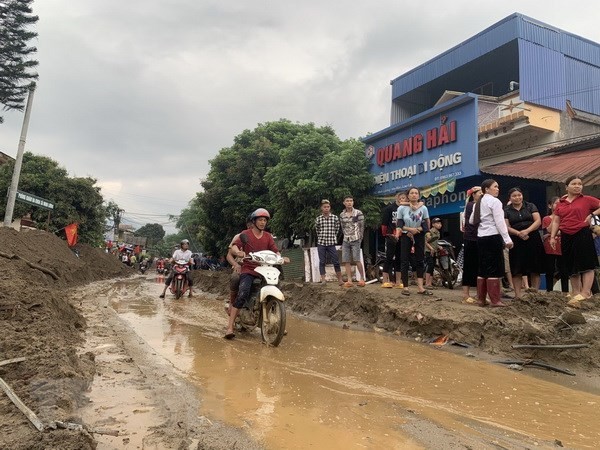 Bùn đất theo lũ trôi về tràn ngập trên Quốc lộ 279. (Ảnh Hồng Ninh/TTXVN).