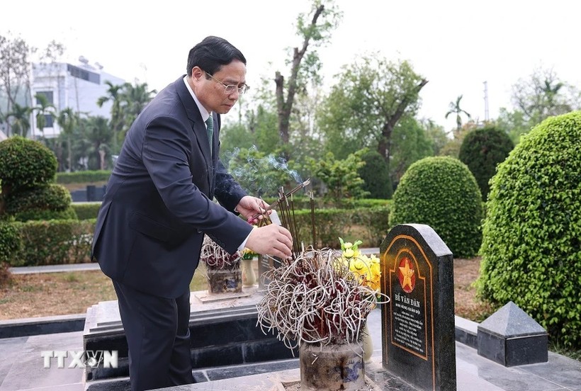 Thủ tướng Phạm Minh Chính thắp hương tại mộ phần các liệt sỹ. (Ảnh: Dương Giang/TTXVN)
