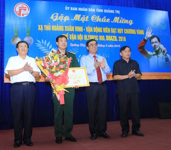 Lãnh đạo tỉnh Quảng Trị tặng hoa chúc mừng xạ thủ Hoàng Xuân Vinh, một người con gốc Quảng Trị anh hùng.