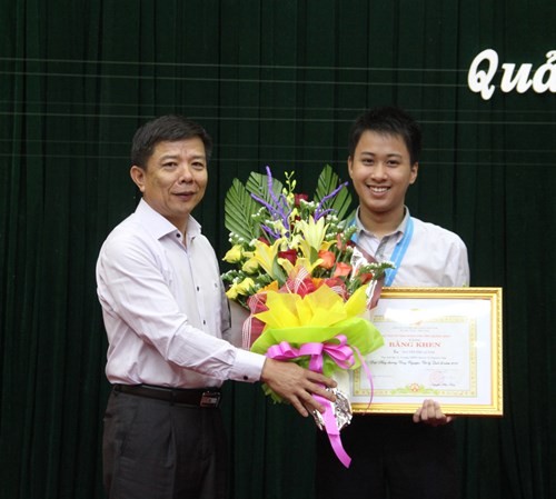 Ông Nguyễn Hữu Hoài - Chủ tịch UBND tỉnh Quảng Bình - tặng bằng khen cho học sinh Nguyễn Thế Quỳnh với thành tích đạt được tại các kỳ thi quốc tế năm 2016.