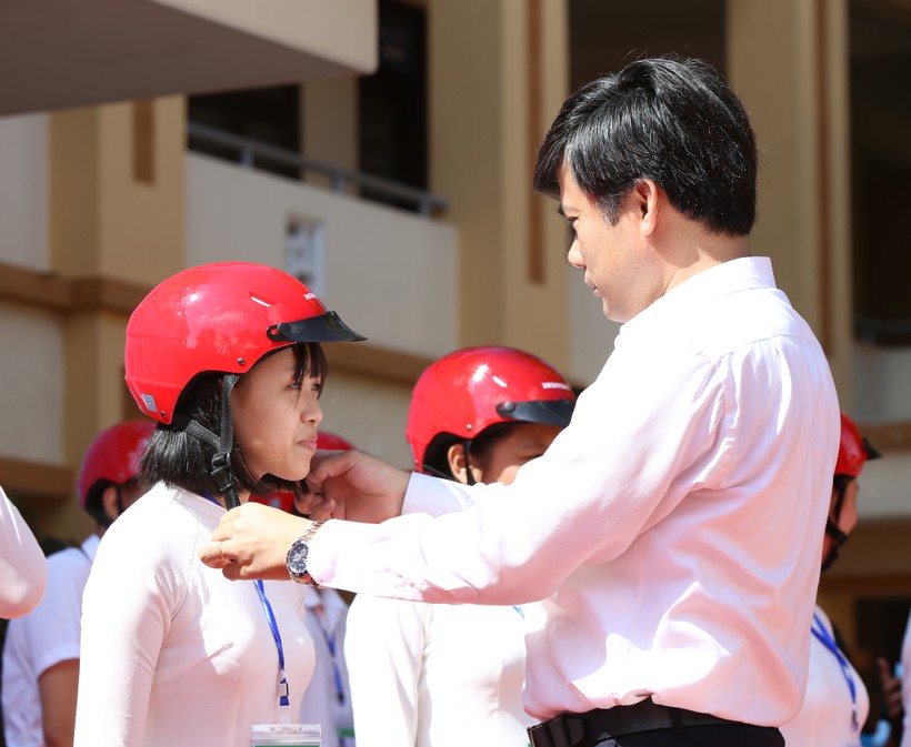 Ông Bùi Văn Linh, Phó Vụ trưởng, phụ trách Vụ Giáo dục Chính trị và Công tác HSSV Bộ GD&ĐT trực tiếp hướng dẫn cách mang mũ cho các em học sinh.