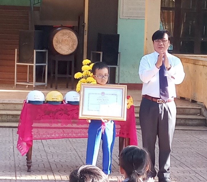 Thừa uỷ quyền của Bộ trưởng Bộ GD&ĐT Phùng Xuân Nhạ, đại diện ngành GD&ĐT tỉnh Quảng Trị trao bằng khen cho học sinh Hoàng Đức Sơn  - tấm gương vượt khó vươn lên trong học tập.