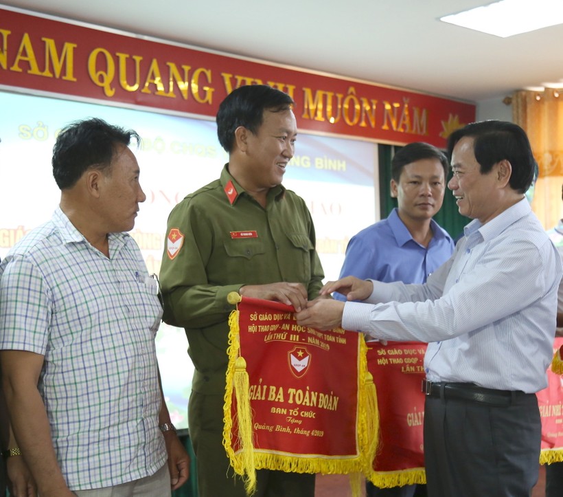 Ông Đinh Quý Nhân, giám đốc Sở GD&ĐT tỉnh Quảng Bình tặng cờ cho các đơn vị đạt giải tại hội thao.
