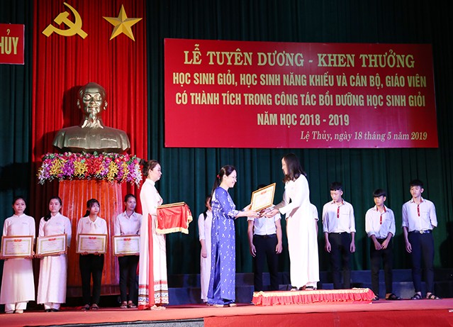 Bà Ninh Thị Hoà, phó chủ tịch UBND huyện Lệ Thuỷ trao giấy khen cho học sinh đạt thành tích cao trong các kỳ thi năm học 2018-2019.